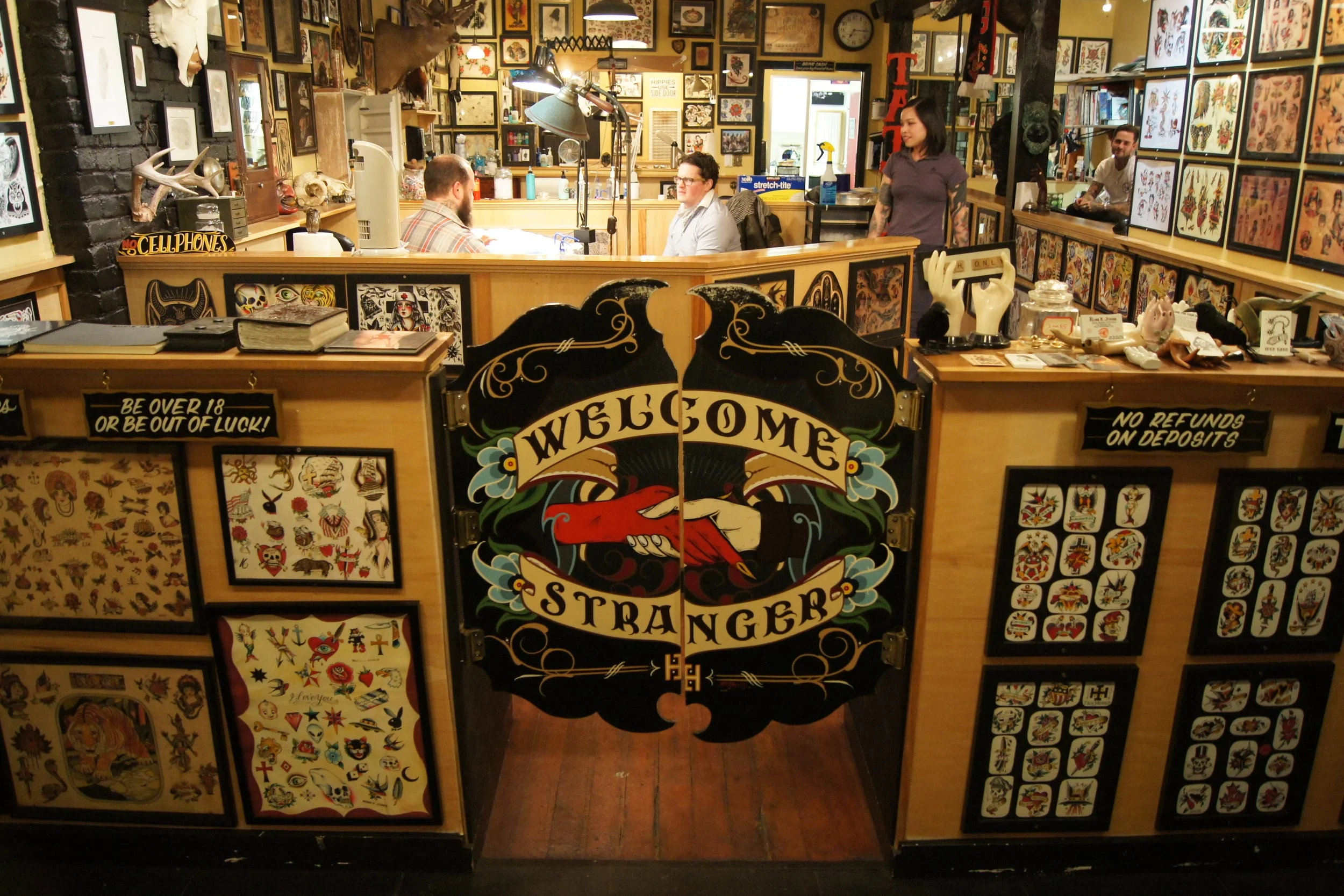 Inside Idle Hand Tattoo -- flash-covered walls, warm amber light